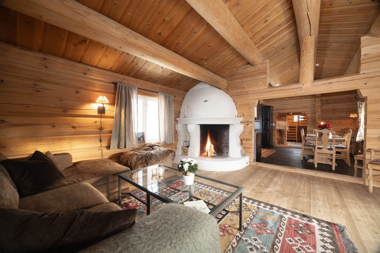 En lun stue der peisen knitrer og tømmerveggene omfavner rommet, mens utsikten mot fjellene bare kan nytes. Galleribilde