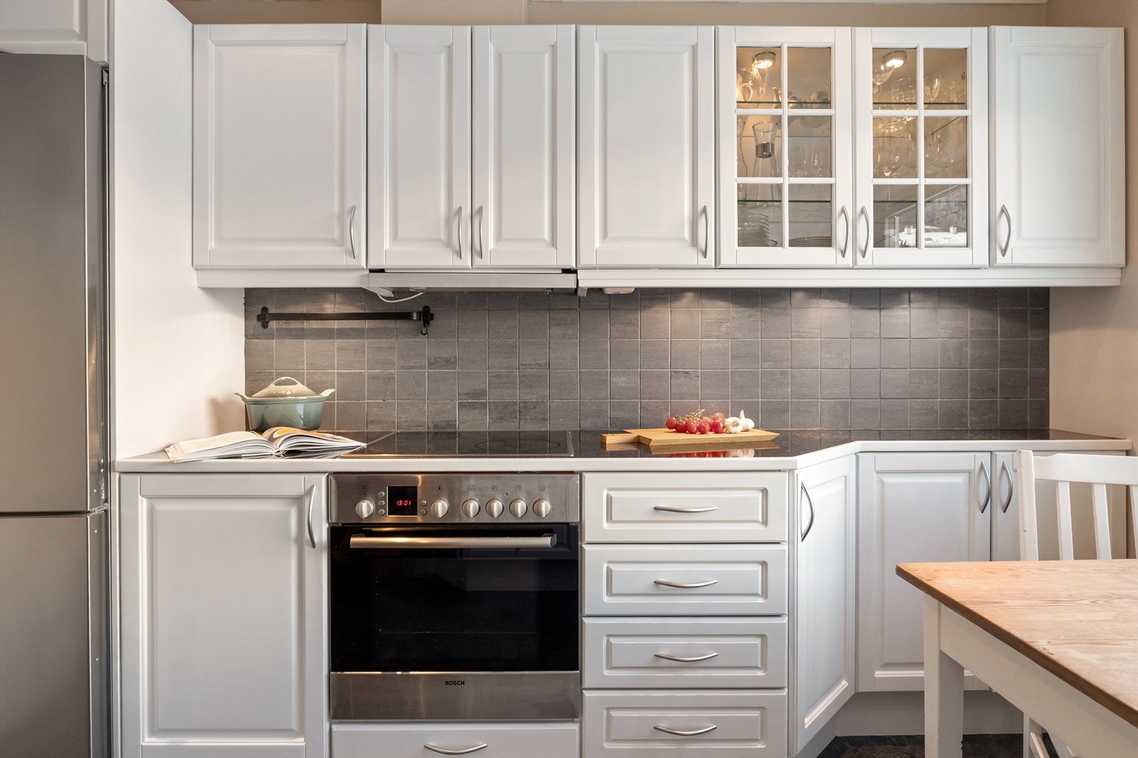 Integrerte hvitevarer som keramisk topp, stekeovn, oppvaskmaskin og nisje til kjøleskap. Galleribilde