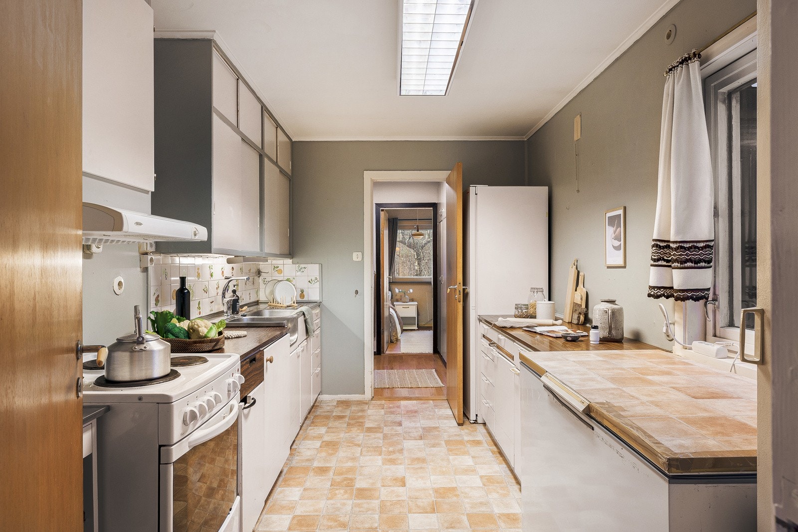 Kjøkkenet har belegg på gulv, slette malte vegger og himling. Kjøkkeninnredningen har slette fronter og laminat benkeplate med nedfelt vask i stål. Galleribilde