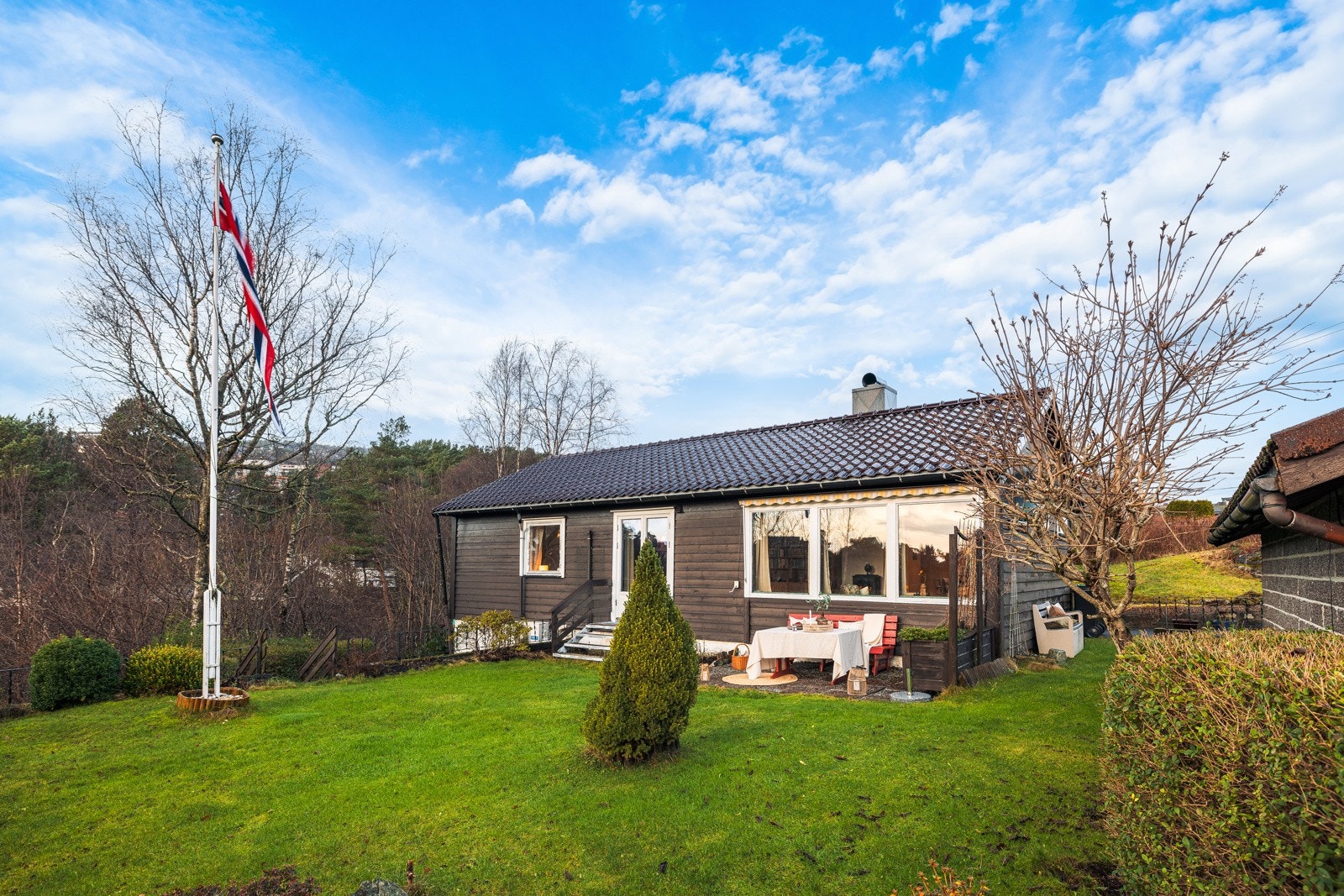 Eiendommen har en flat og solrik tomt med fine uteområder for lek, opphold og sosiale sammenkomster. Galleribilde
