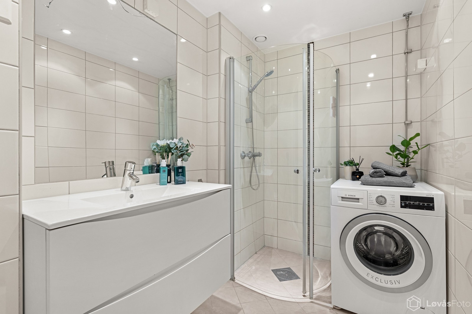 Rommet er utstyrt med vegghengt servantinnredning med skuffer, heldekkende servant, integrert speil., vegghengt toalett og dusjhjørne med glassdører. Vaskemaskin medfølger. Galleribilde