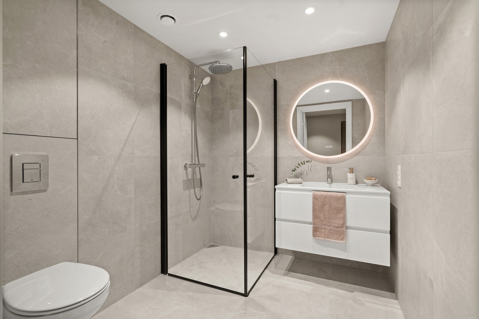 Boligen har to lekre bad med moderne fliser, varmekabler, dusjvegger i glass og armaturer fra Grohe Galleribilde