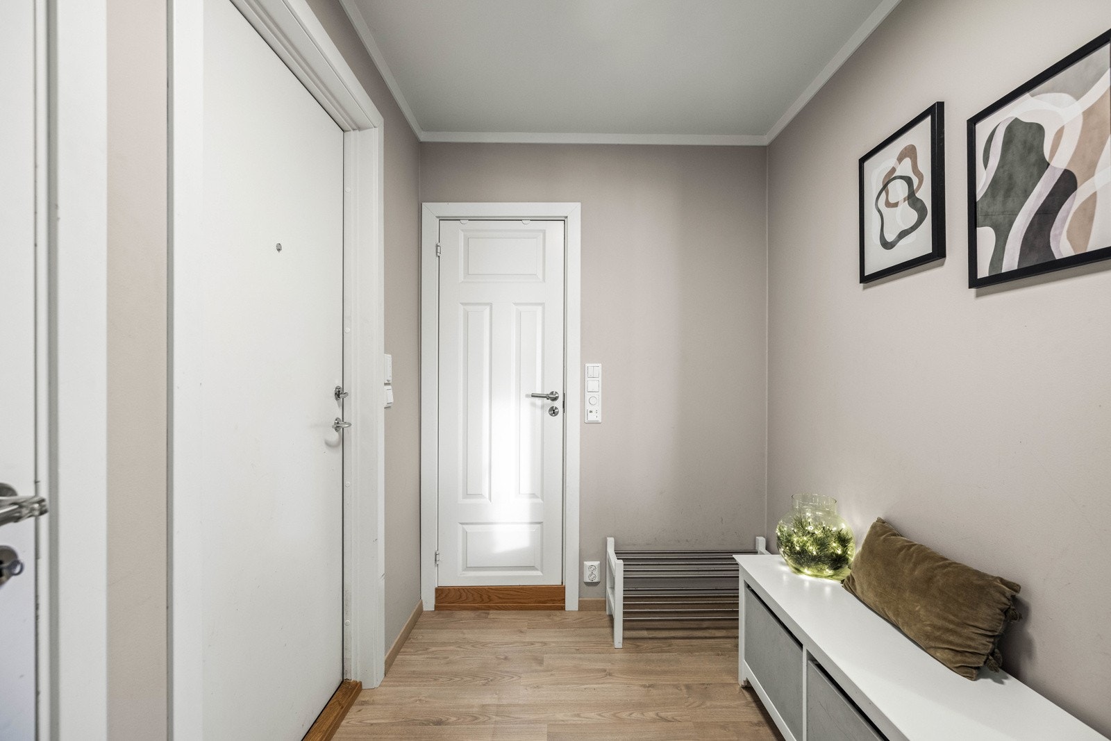 Lys og hyggelig entré med plass til oppheng av klær og lagring av sko. Galleribilde