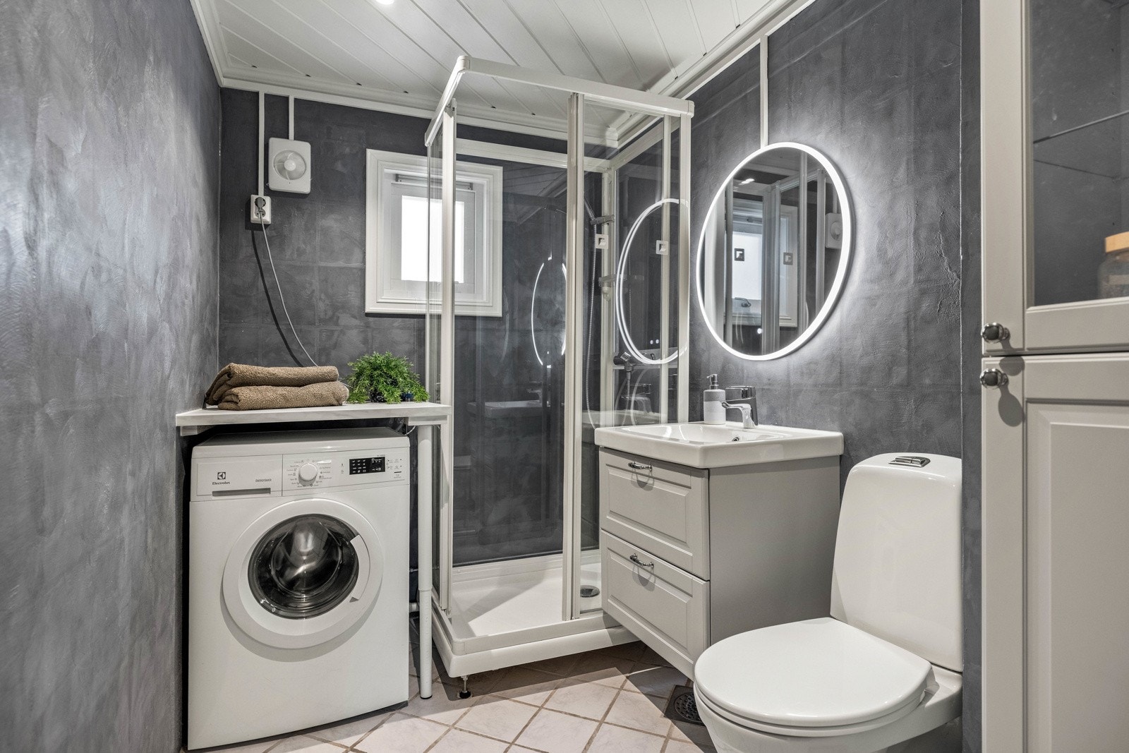 Badet har flislagt gulv med varmekabler, mikrosement på flislagte vegger og malt panel i himling. Galleribilde