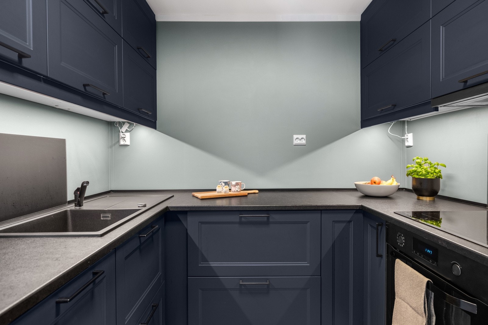 Et flott kjøkken fra 2022 med innredning langs tre vegger, takhøye overskap og integrerte hvitevarer. Galleribilde