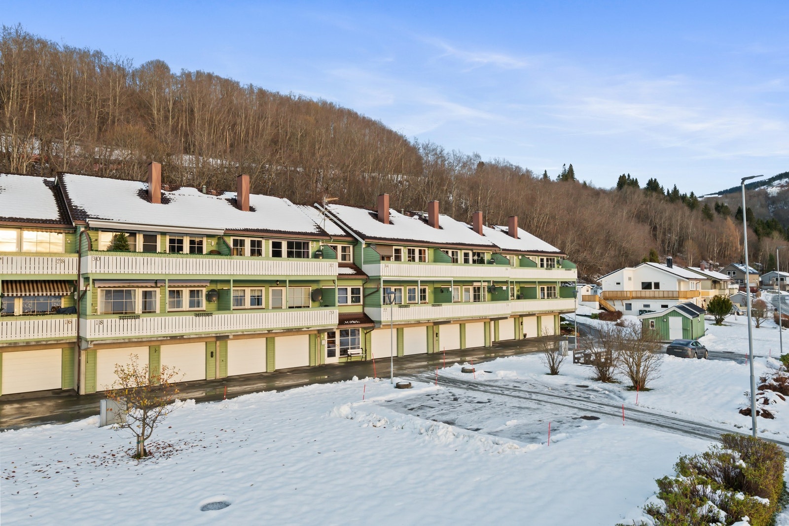 Store fellesarealer med gjesteparkeringer og flere sittegrupper. Galleribilde