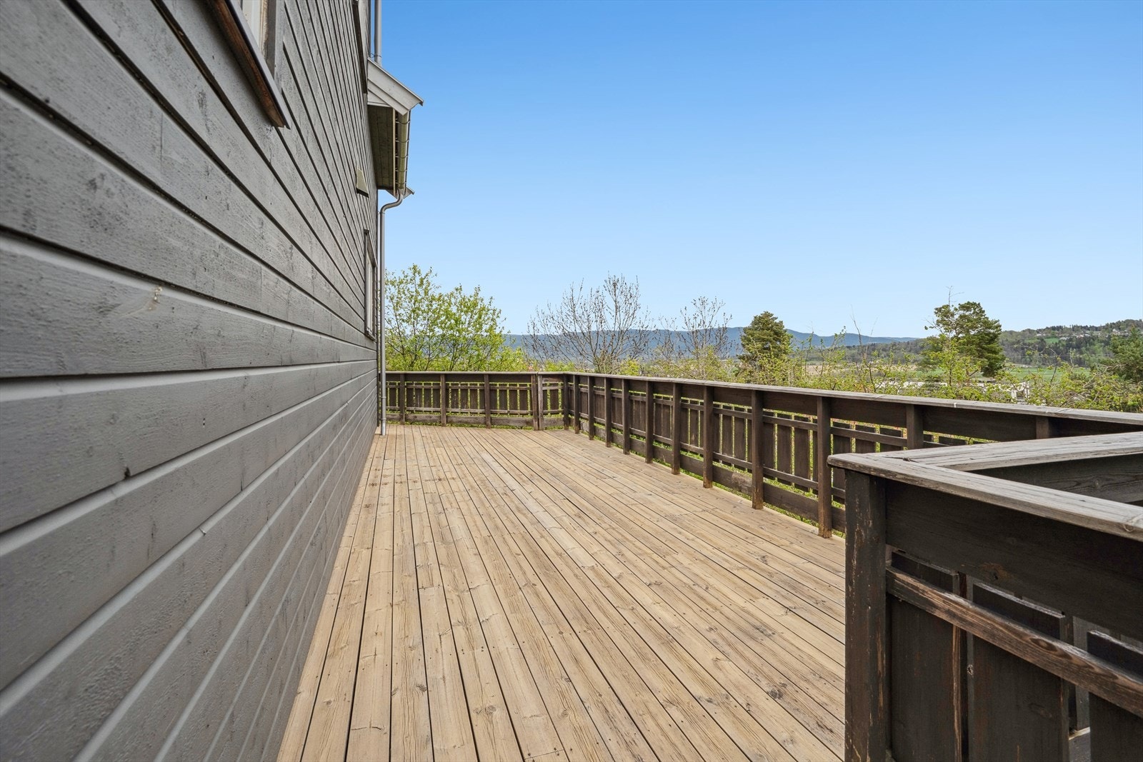 Fra kjøkkenet er det utgang til terrasse som går rundt store deler av boligen. Galleribilde
