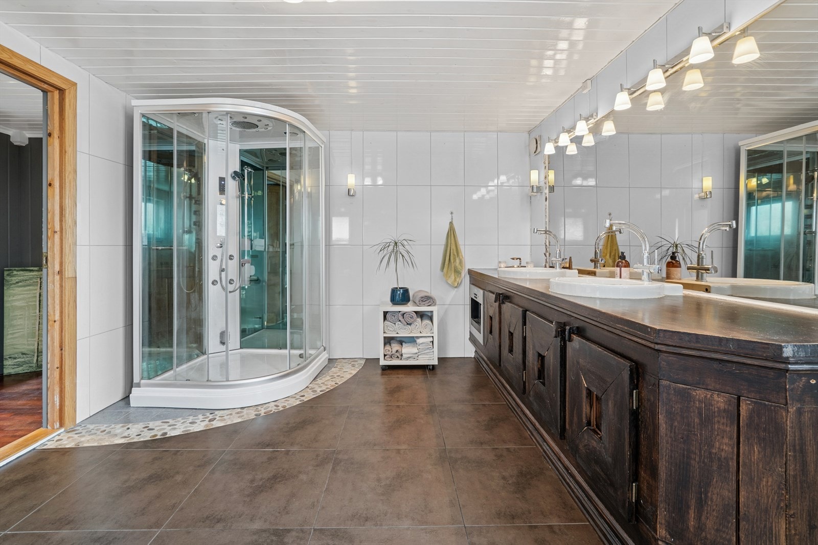 Baderom med fliser og gulvvarme. Badet er innredet med dobbel servant, dusjkabinett og toalett. Galleribilde