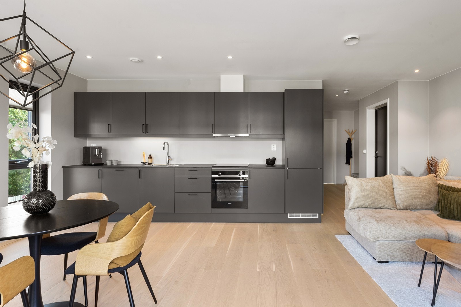 Flott kjøkken i moderne stil med integrerte hvitevarer. Innredningen er i sort utførelse. Galleribilde