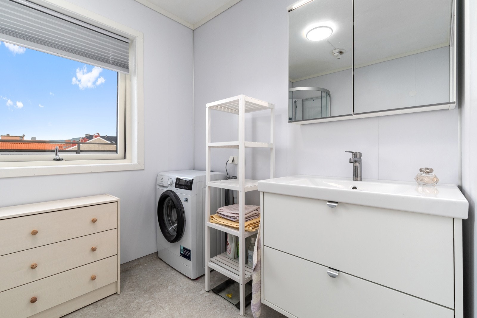 Baderommet inneholder servant og overskap, dusjkabinett, skapplass og opplegg for vaskemaskin/tørketrommel, samt wc. Galleribilde