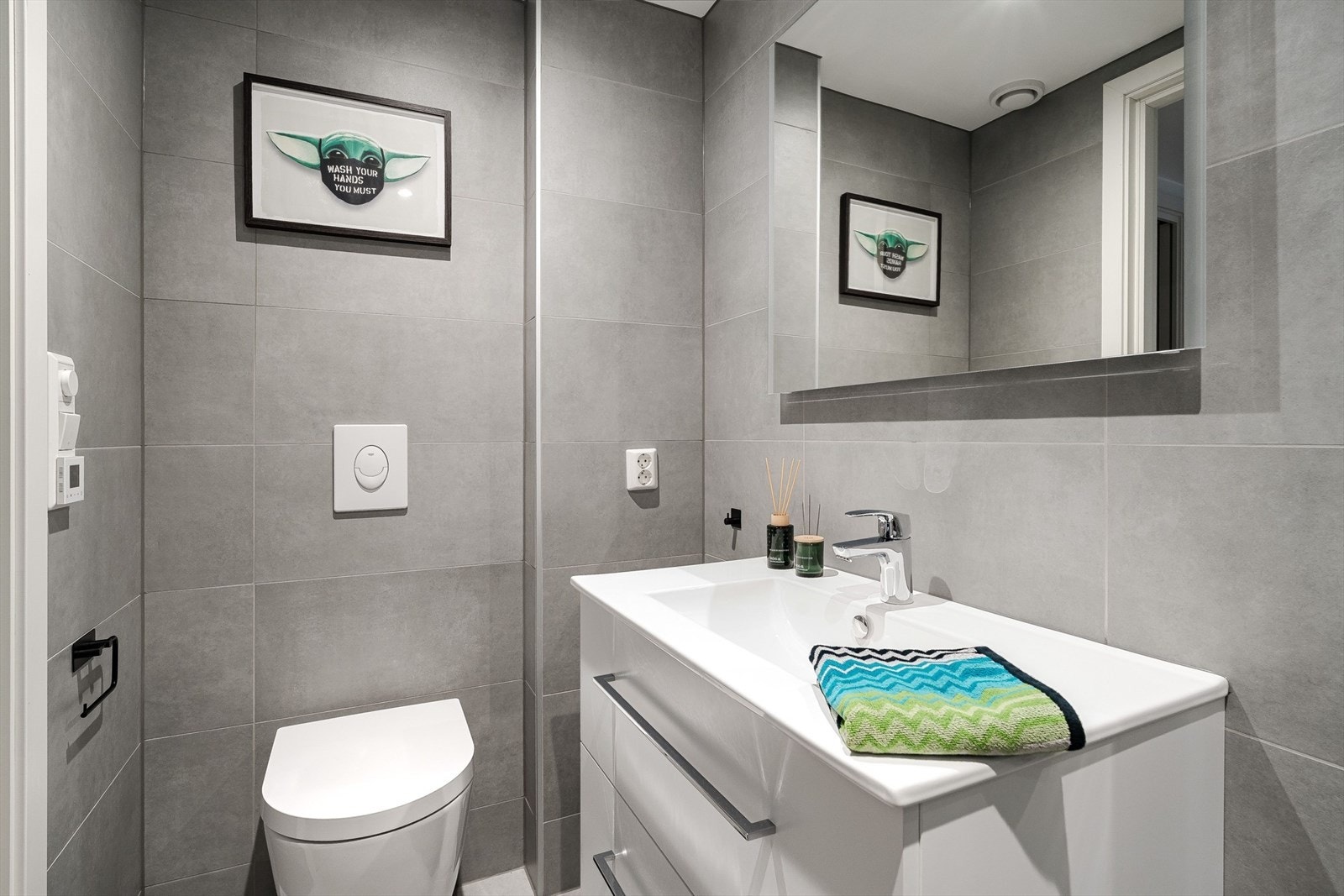 Lys baderomsinnredning og speil over vask Galleribilde