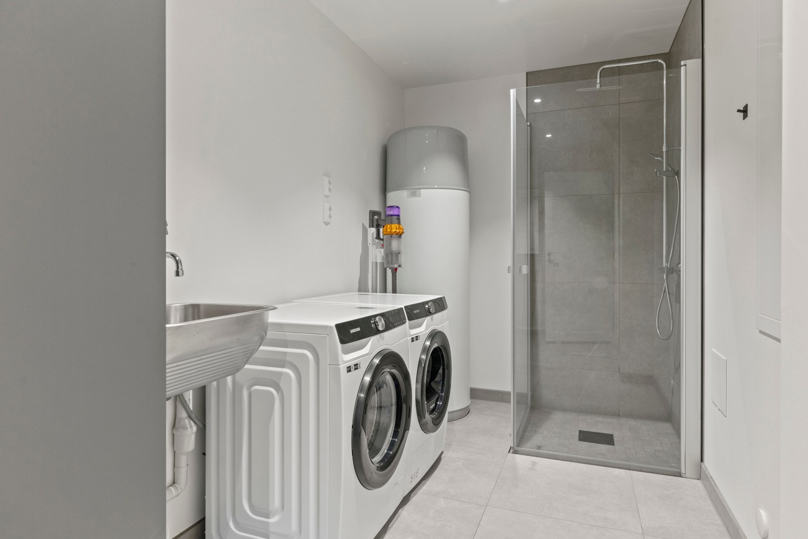 Praktisk vaskerom med støpt og flislagt gulv med elektriske varmekabler. Galleribilde