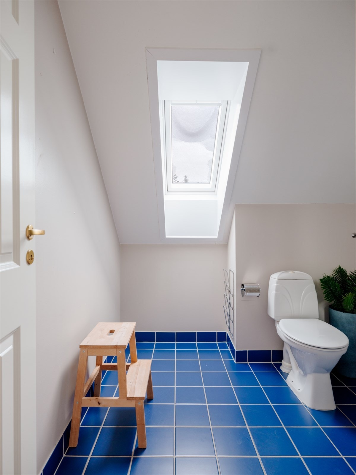 Bad i 2. etasje med flislagt gulv, elektriske varmekabler og takvindu som gir naturlig lys og god ventilasjon Galleribilde
