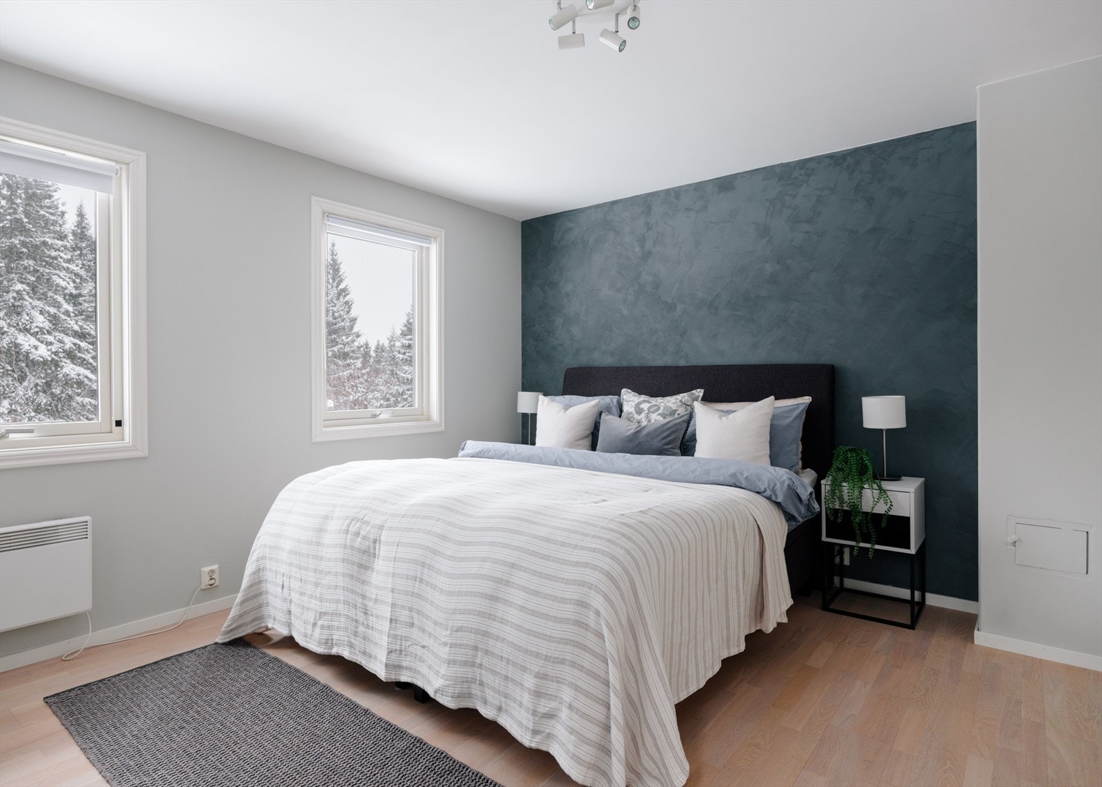 Stort hovedsoverom med garderobeskap, store vindusflater mot skogen og utgang til hage Galleribilde