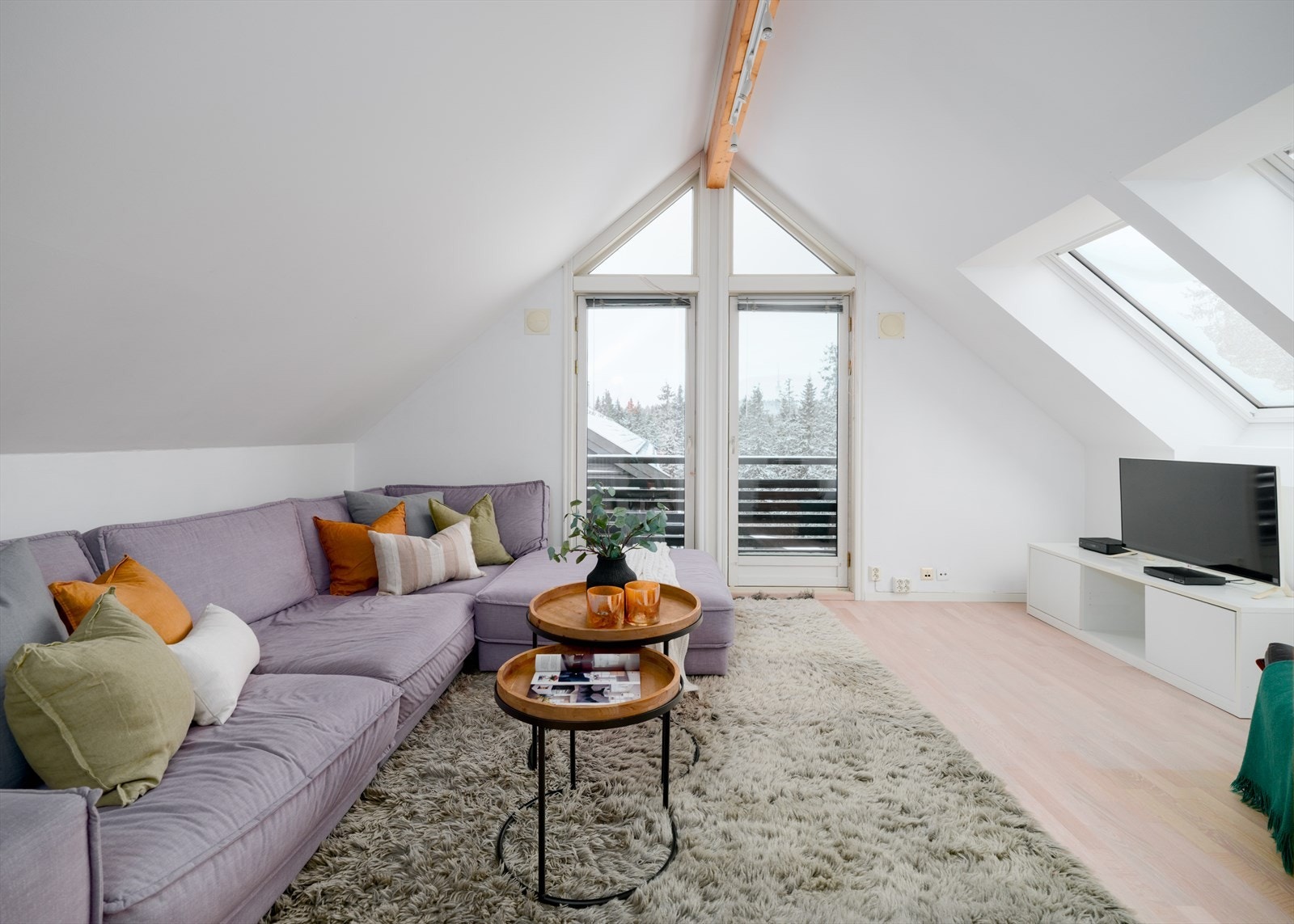 Store vindusflater med fransk balkong og takvinduer sikrer gode lysforhold og fin romfølelse Galleribilde