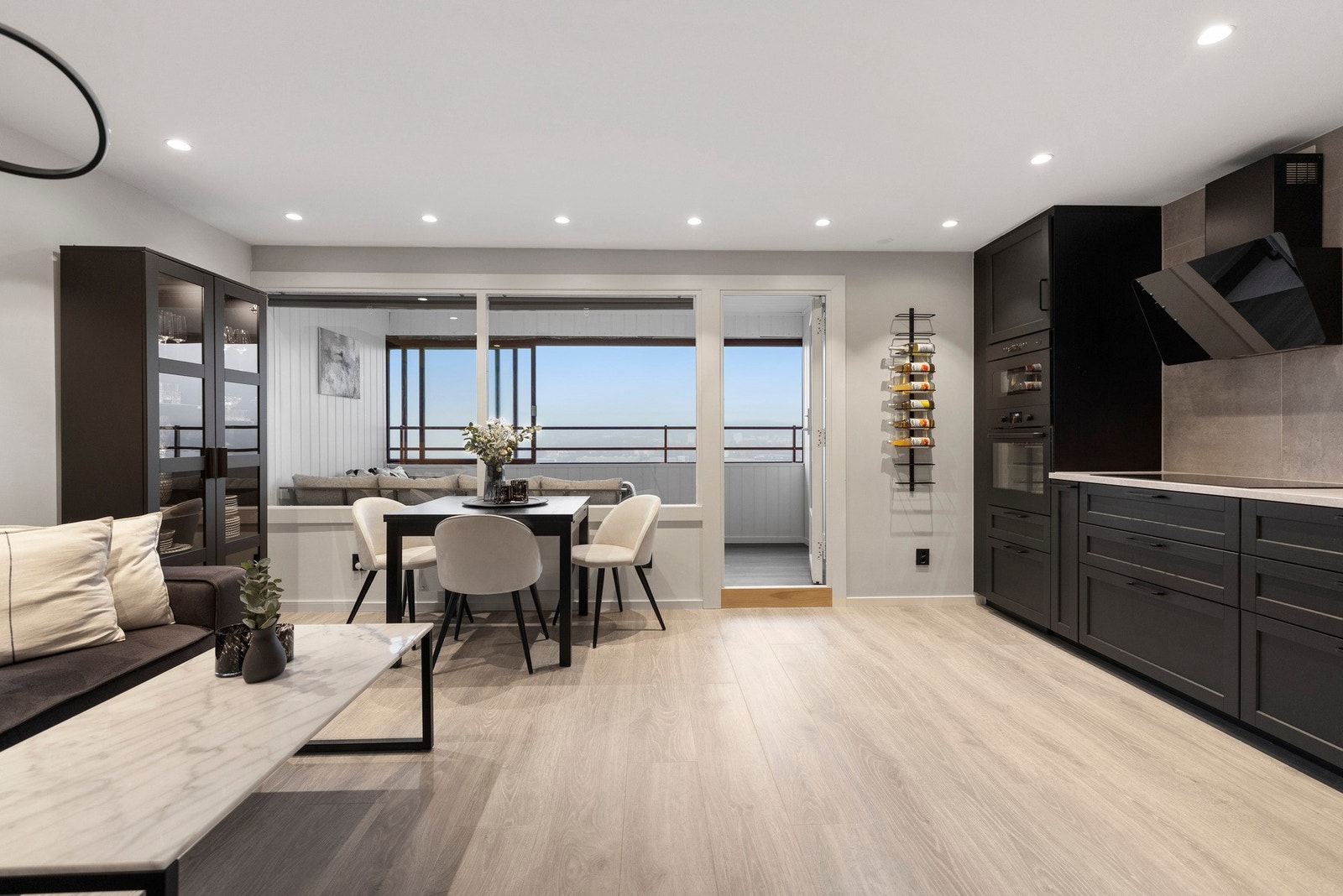 Stuen ligger i en åpen løsning med kjøkkenet og har lekre, moderne overflater Galleribilde