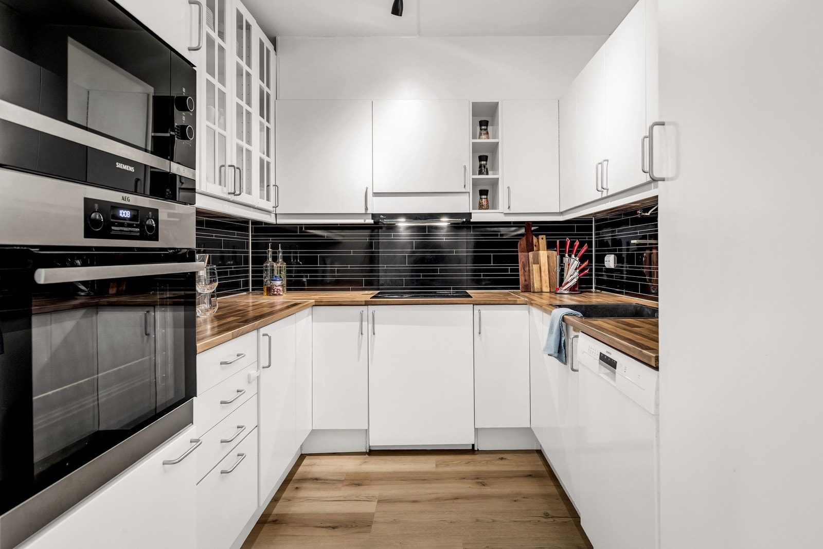 Sigdal kjøkkeninnredning fra byggeår med glatte fronter og laminat benkeplater. Integrert kjøleskap og induksjonsplate er også fra 2021. Galleribilde