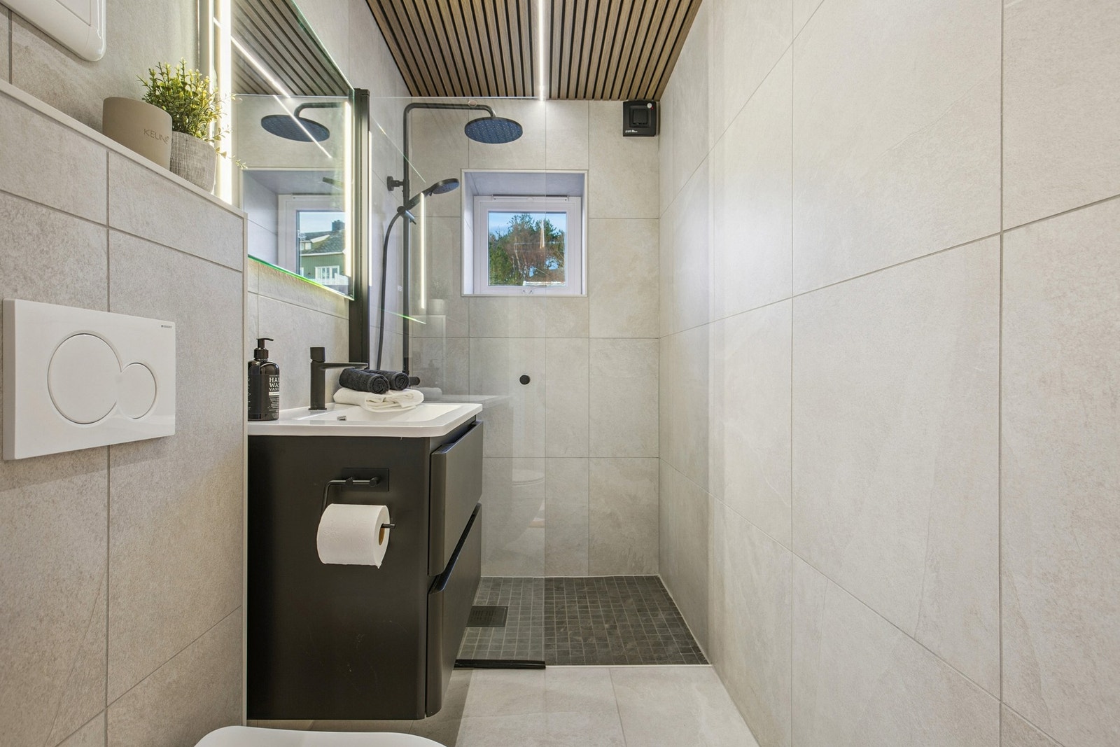 Badet har innredning med nedfelt servant, veggmontert toalett og innfelt dusjsone. Galleribilde