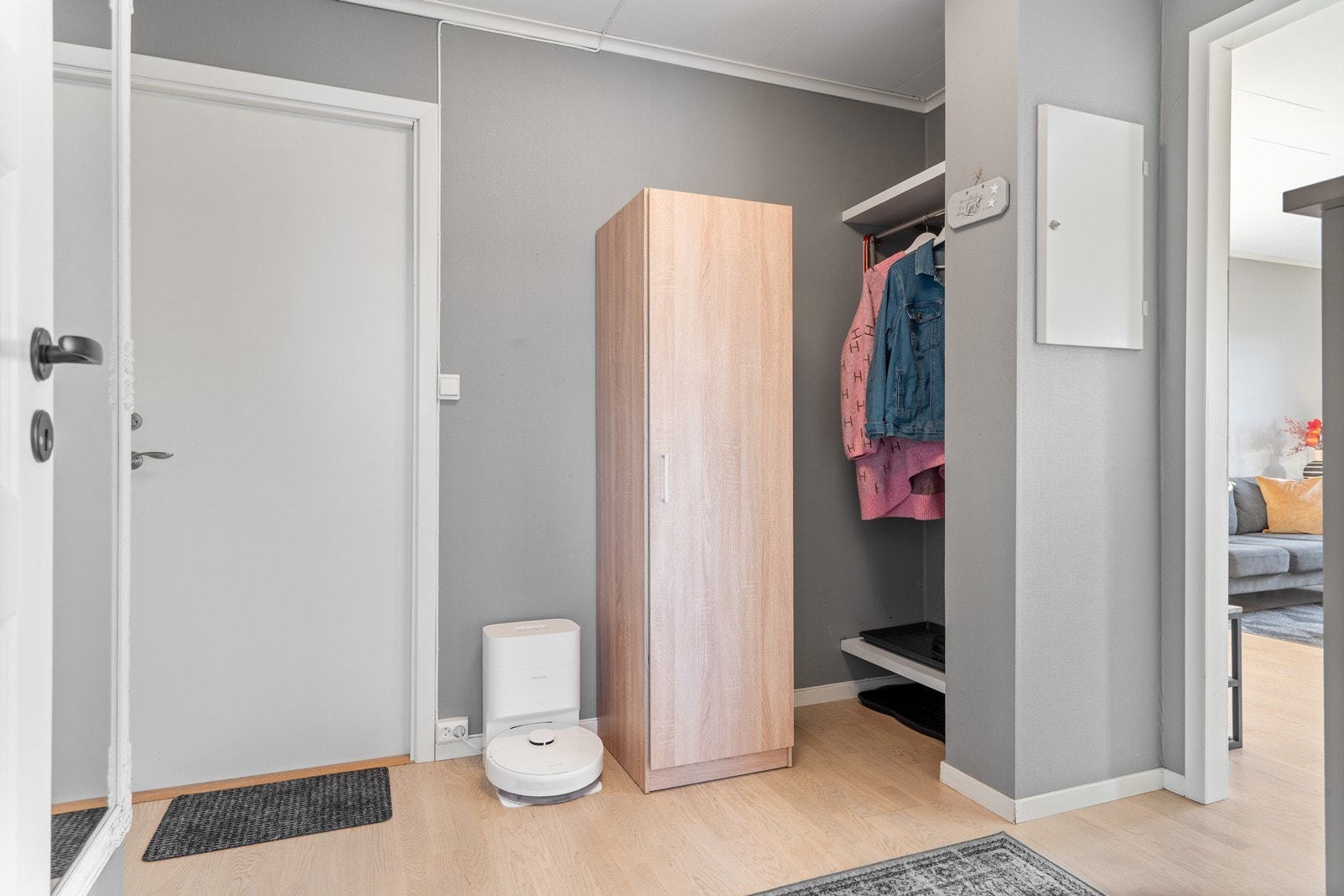 Inngang til gang med parkett på gulv, garderobeskap og terskelløs åpning til stue/kjøkken. Galleribilde