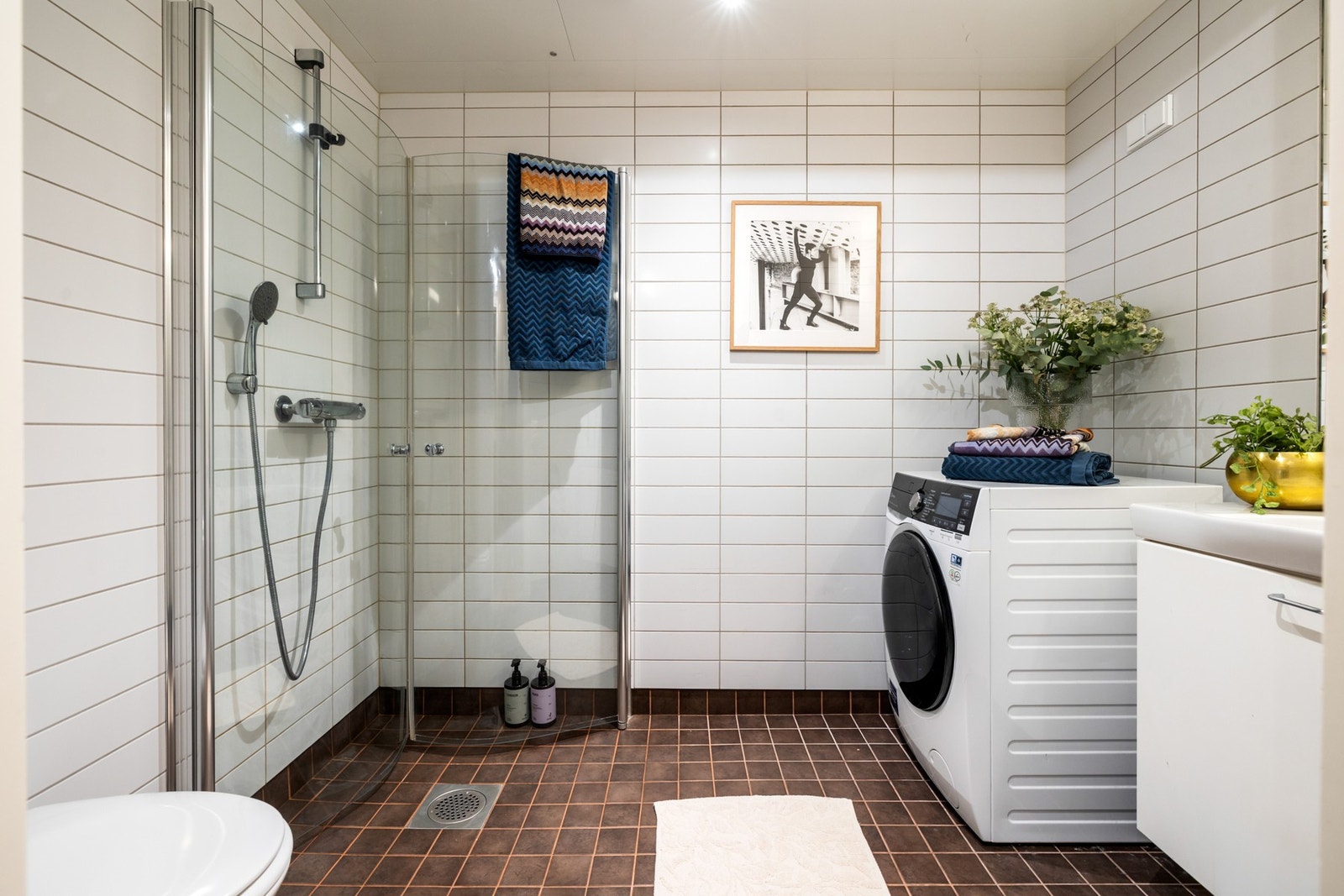 Tidløst bad med flislagt gulv med elektriske varmekabler og flislagte vegger. Innvendig himling er utført med plater og downlights. Galleribilde