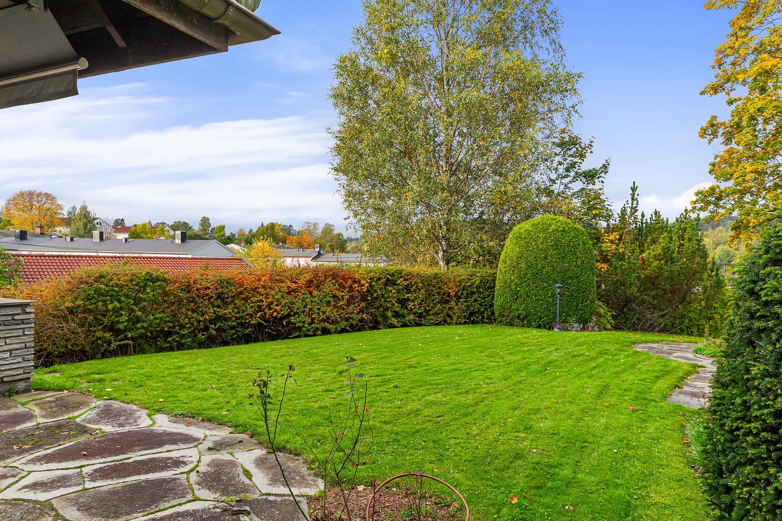 Utenfor bassengrommet er det skiferlagt terrasse med markise og utvendig belysning Galleribilde
