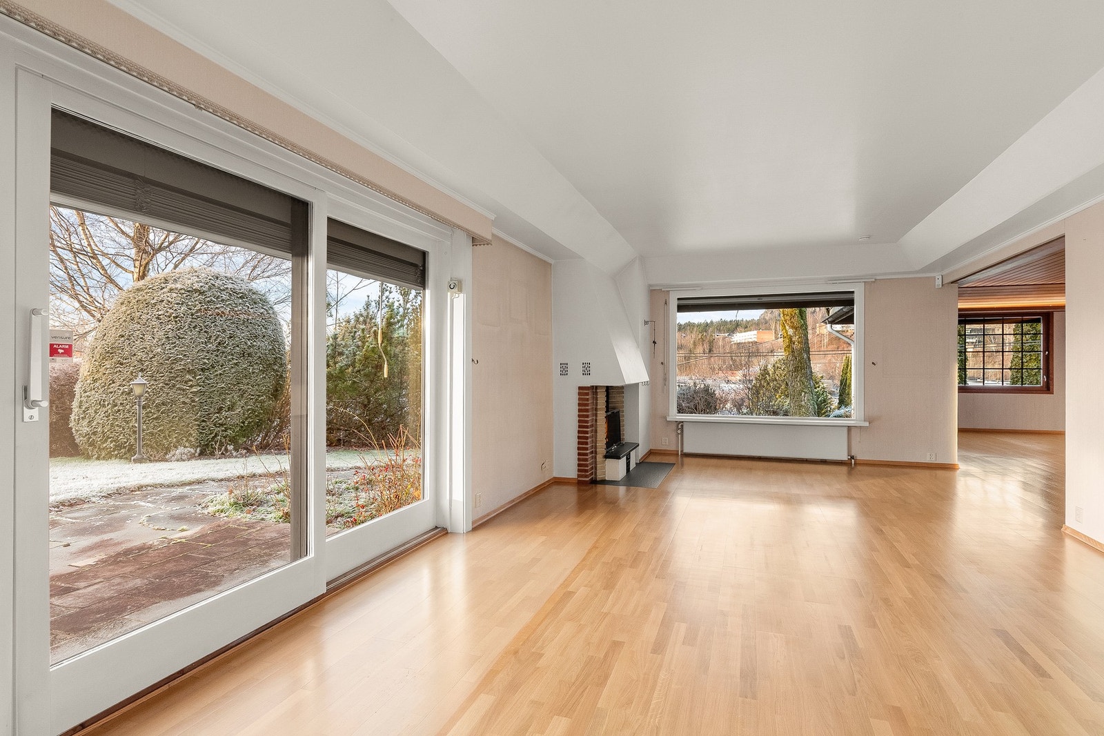 Rommet er lyst med store vinduer ut mot hagen Galleribilde