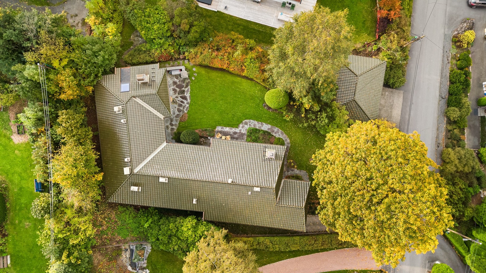 Pent opparbeidet tomt hvor busker gir skjerming og trær tilfører karakter til eiendommen Galleribilde