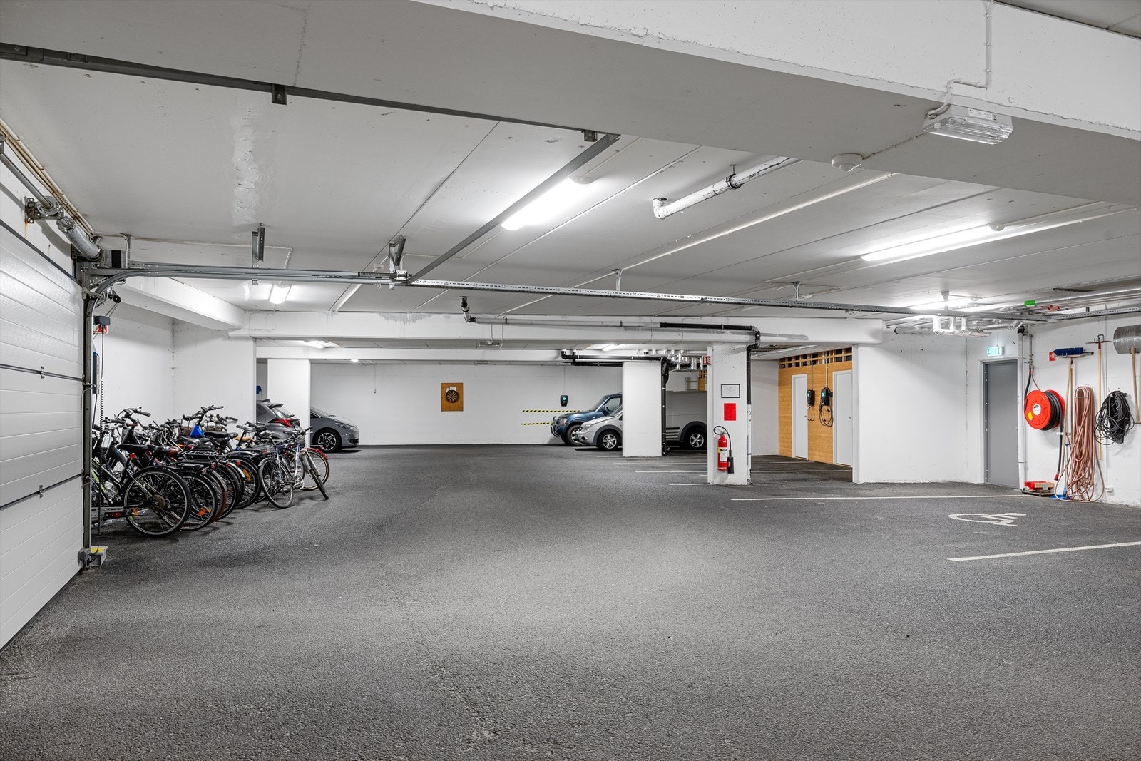 Parkering i lukket anlegg med tilhørende bod. Parkering hvor sølvfarget bil er plassert. Galleribilde