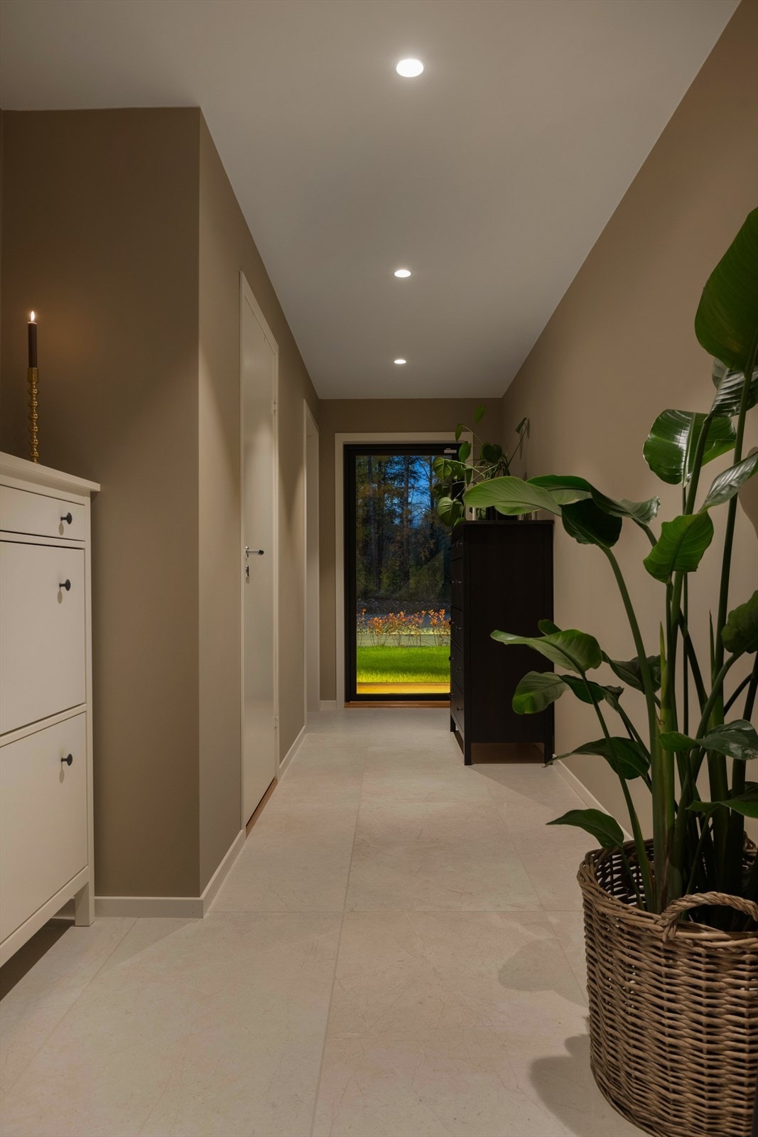 Gangen har rikelig med lys og egen utgang til boligens markterrasse. Galleribilde