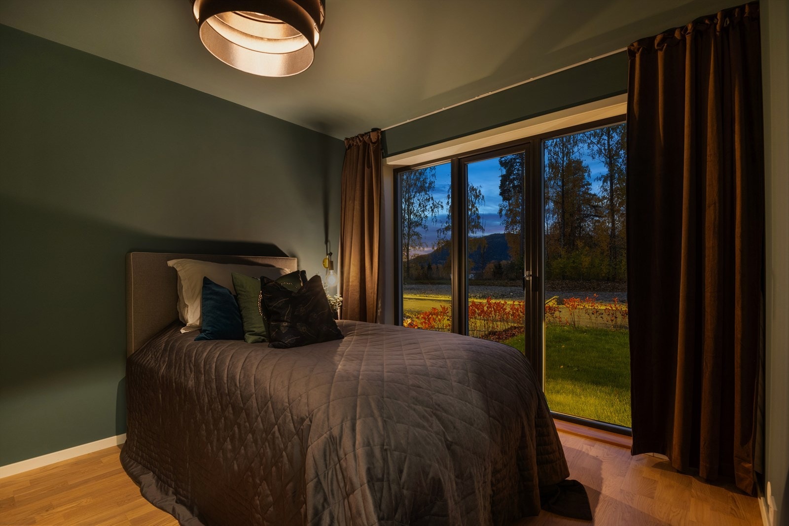 Soverom i 1.etg i en lun mørk grønn tone. Soverommet har store vindusflater som slipper inn rikelig med lys. Galleribilde