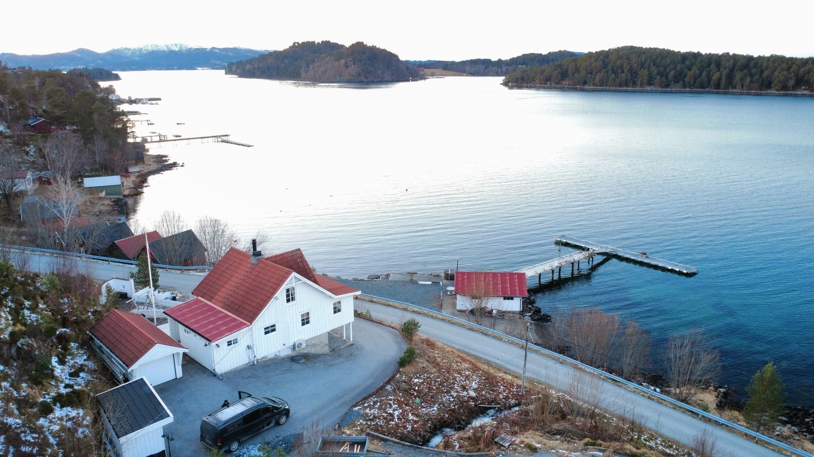 Flott uteområde med grillplass, strandlinje, brygge og naust. Galleribilde