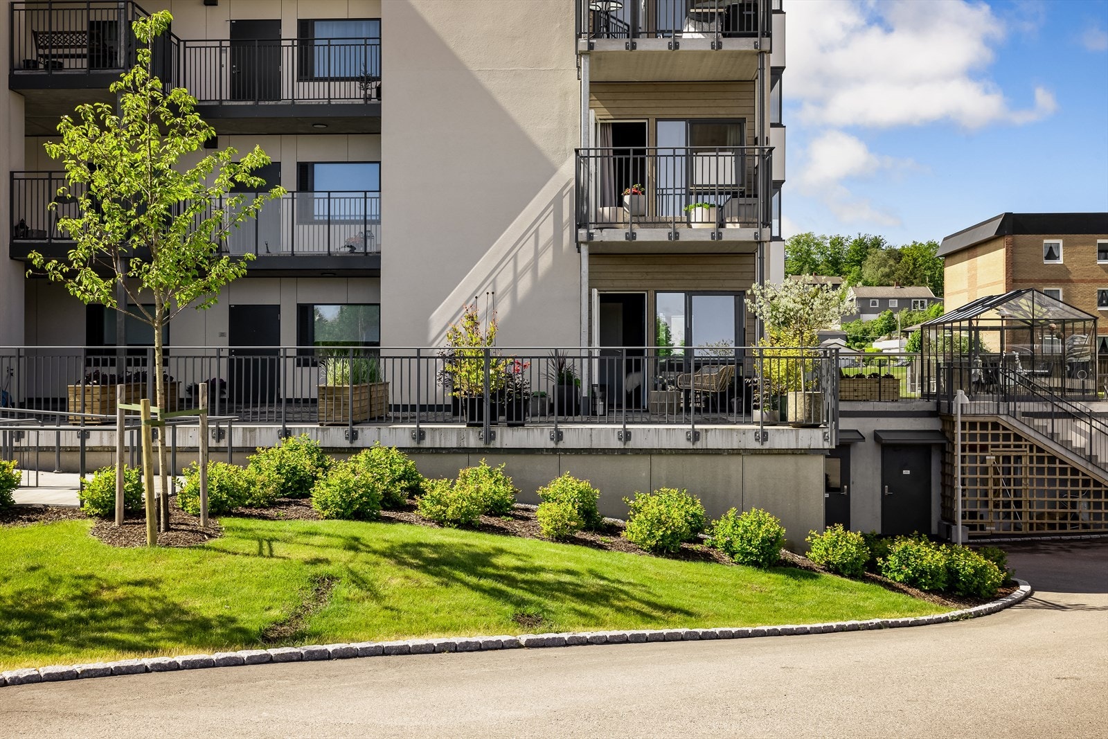 Leiligheten har hyggelig uteplass på inngangssiden av bygget. Galleribilde