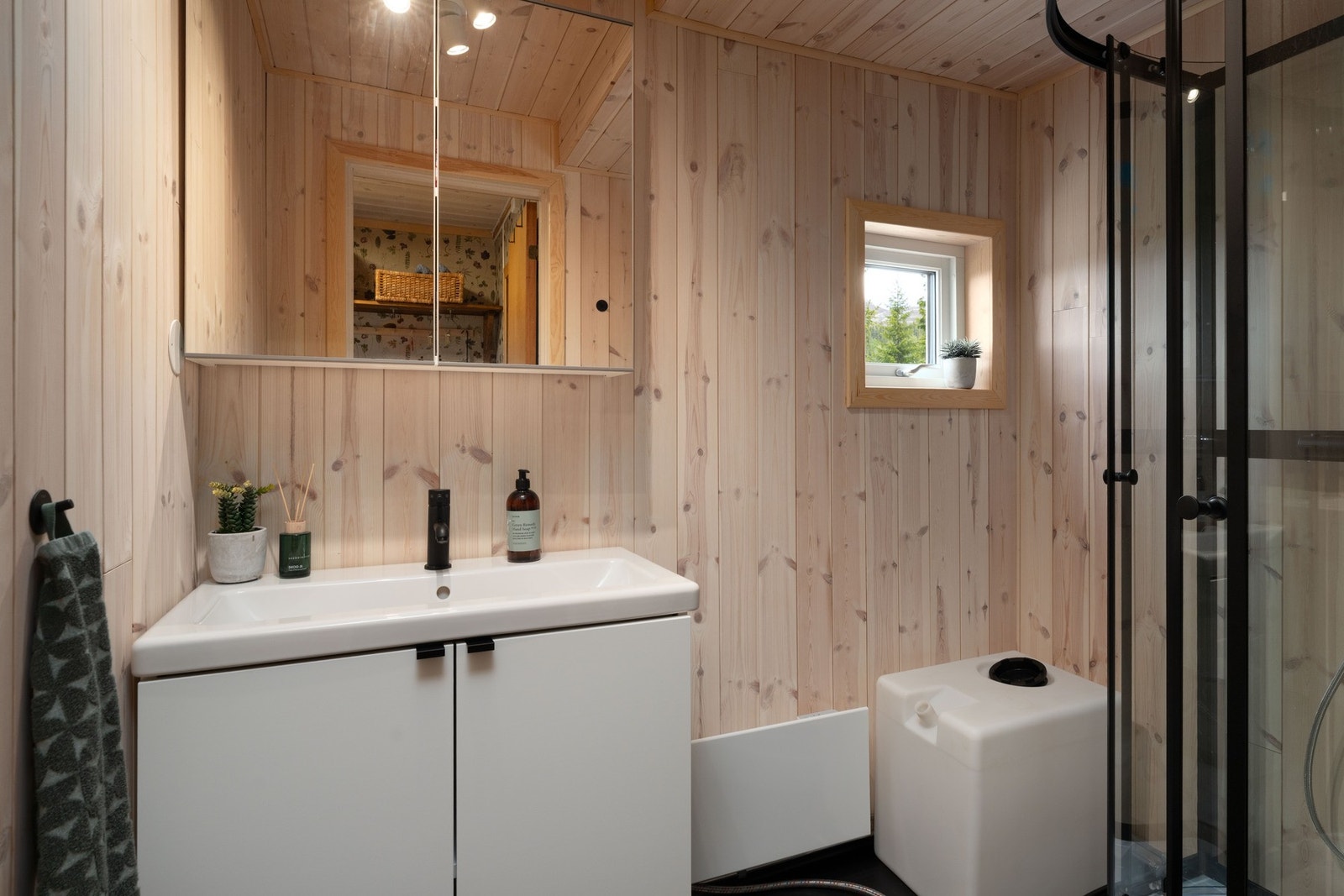 Hyttebadet er enkelt men med vask og dusj, vanntanken fylles opp med vann som medbringes eller hentes i bekken. Galleribilde
