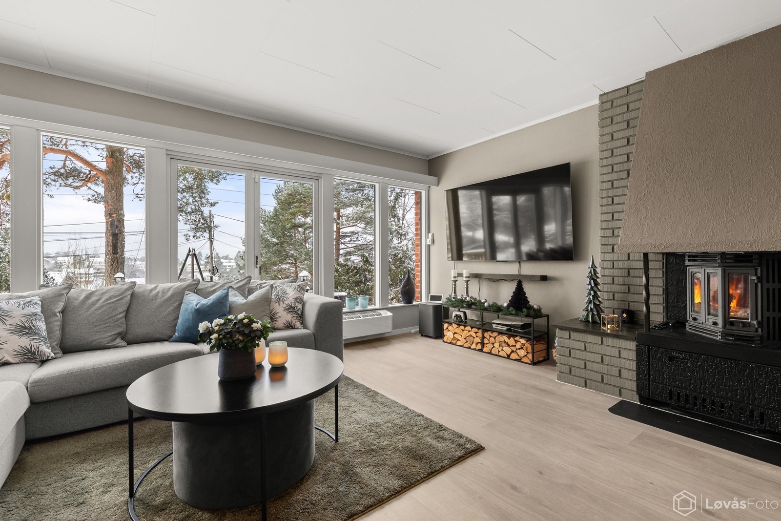 Romslig og kombinert stue og spisestue med store vindusflater og peis. Utgang fra rommet til uteområdet. Galleribilde