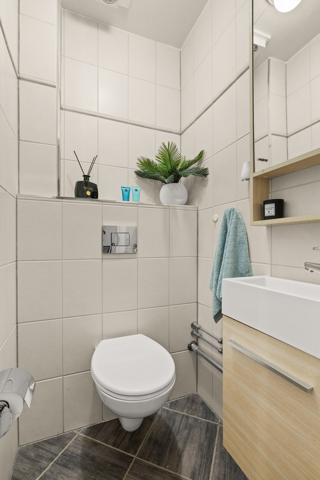 Separat gjestetoalett fra 2013 med flislagt gulv og vegger. Toalettrommet er utstyrt med vegghengt servantskap med glatt front og nedsenket servant, vegghengt speilskap og vegghengt toalett. Galleribilde