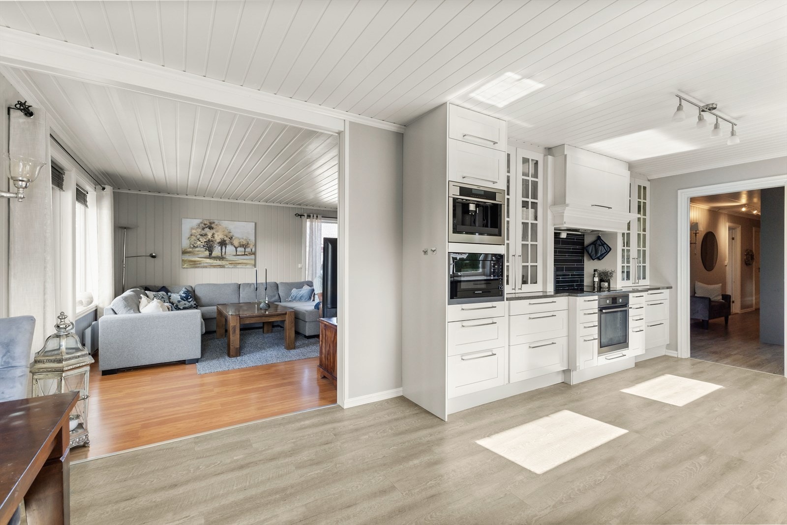 Kjøkkenet fremstår lyst og innbydende, med klassiske, profilerte fronter og en benkeplate i laminat med nedfelt oppvaskkum Galleribilde