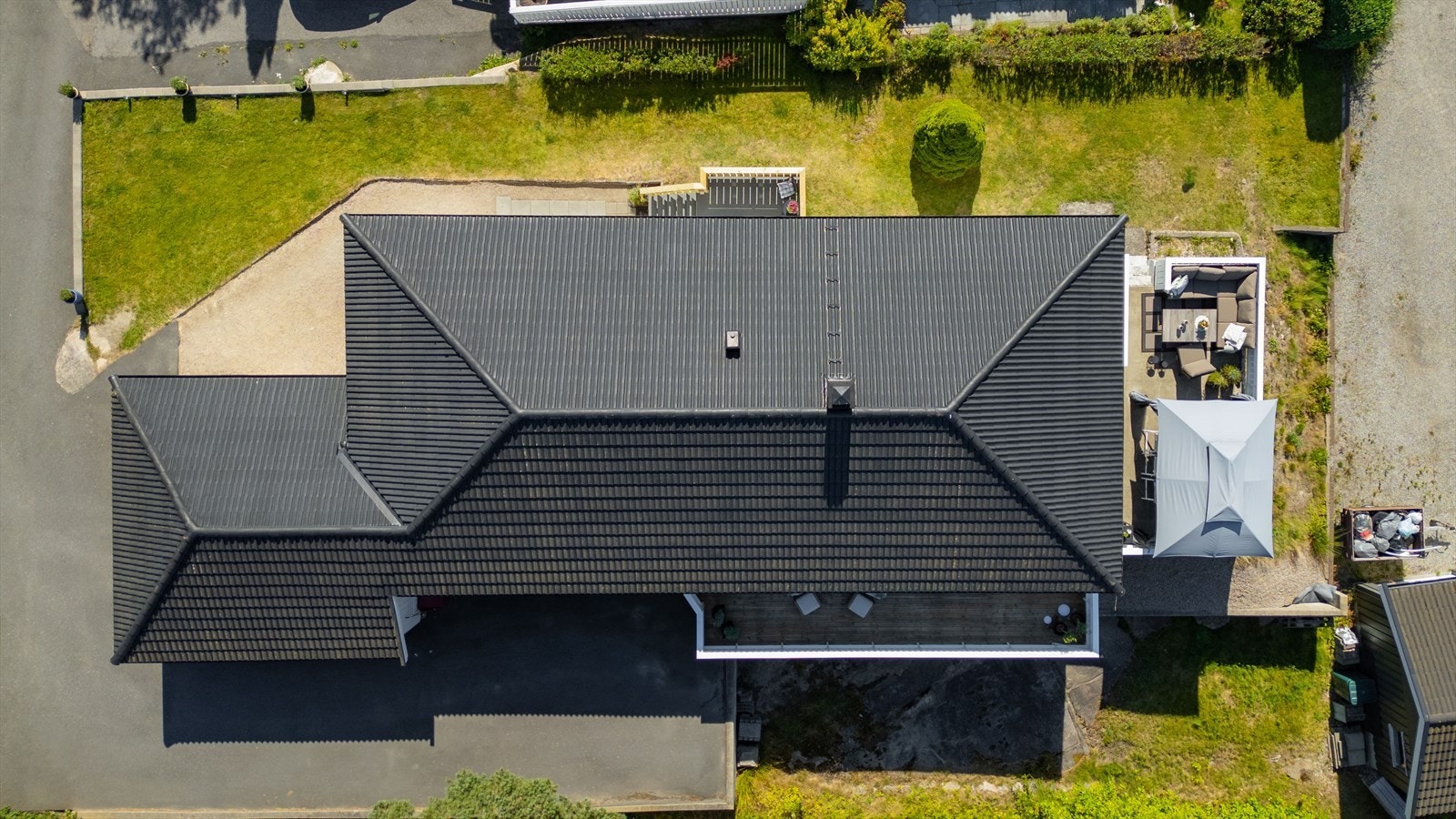 Eiendommen ligger på en relativt flat tomt som er pent opparbeidet med hage, prydbusker og diverse beplantning som bidrar til et grønt og trivelig utemiljø Galleribilde