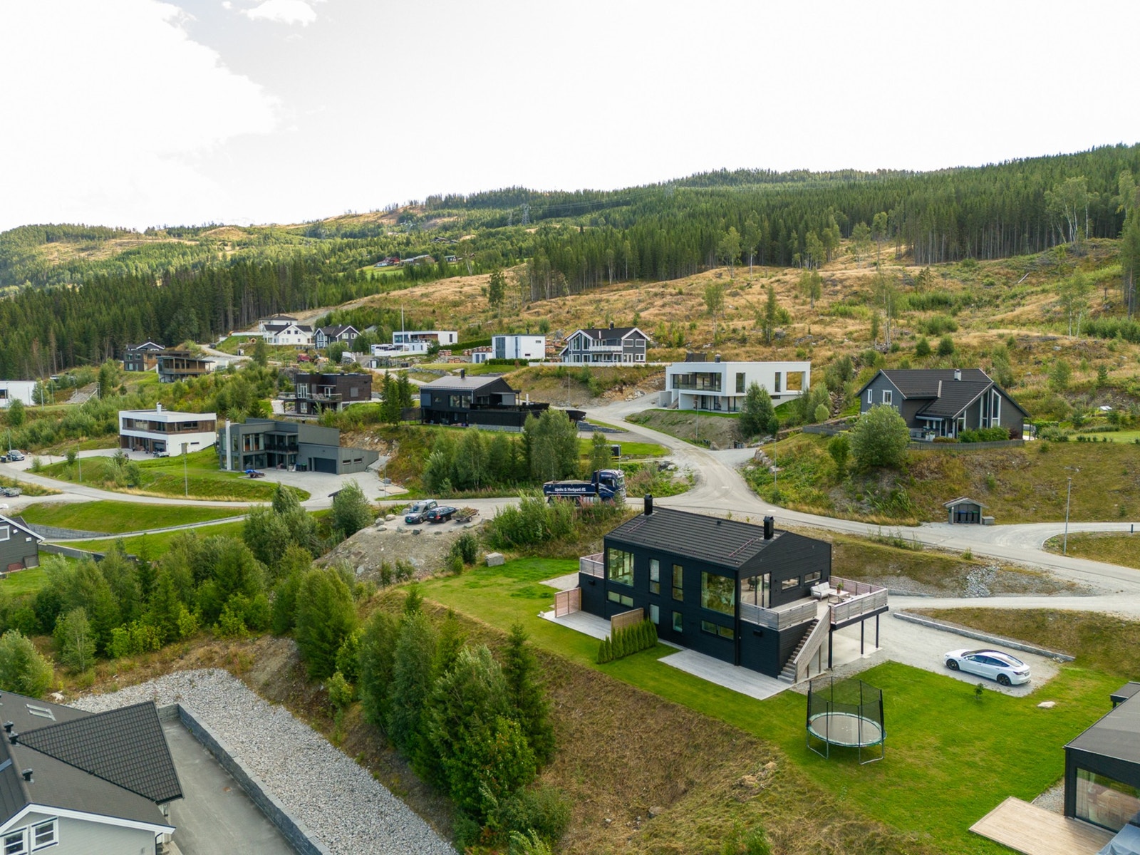 Tomten er felles med den andre delen av tomannsboligen, men har i praksis naturlig skille både ved plenareal og parkering. Galleribilde