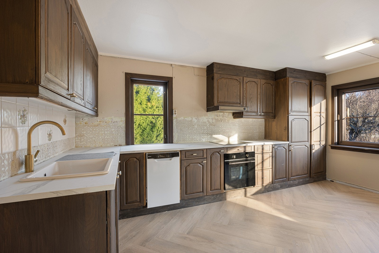 Oppført i en funksjonell L-form har kjøkkenet god arbeidsflyt og skapplass. Galleribilde