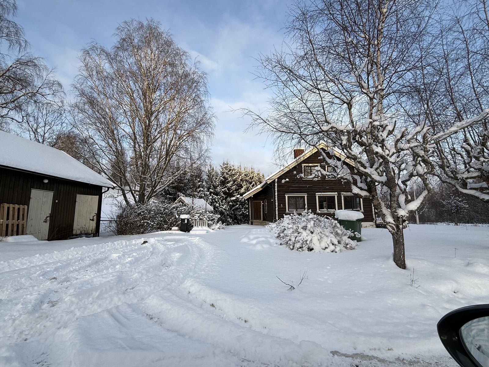 På inngangssiden har huset en gruslagt gårdsplass med mulighet for parkering. Gårdsplassen binder boligen sammen med et frittstående uthus. Galleribilde