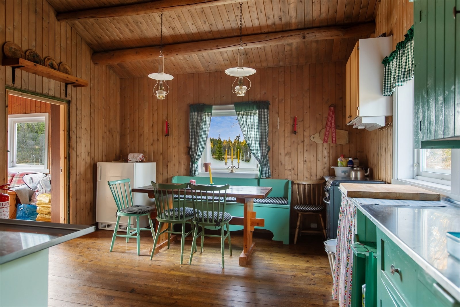 Frittstående komfyr og kjøleskap med propandrift, hvor propandunker er plassert på gulv ved komfyr og i bakrom i kjøleskap. Galleribilde