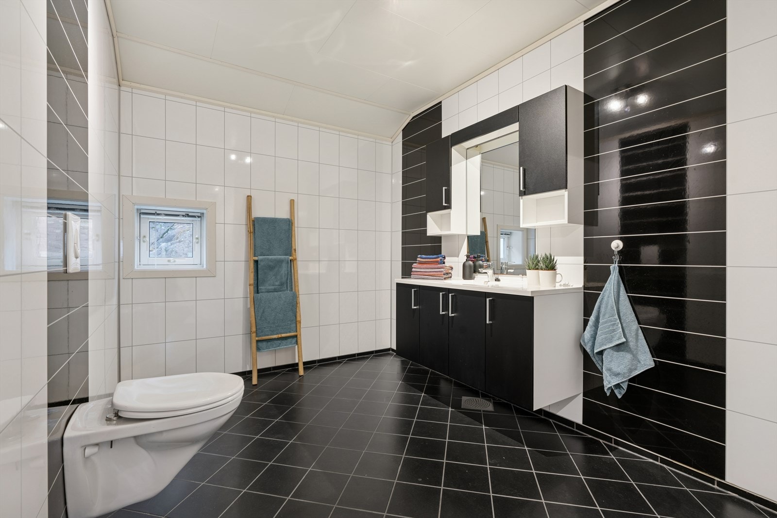 Badet har fliser på gulvet og våtromsplater på veggene. Galleribilde