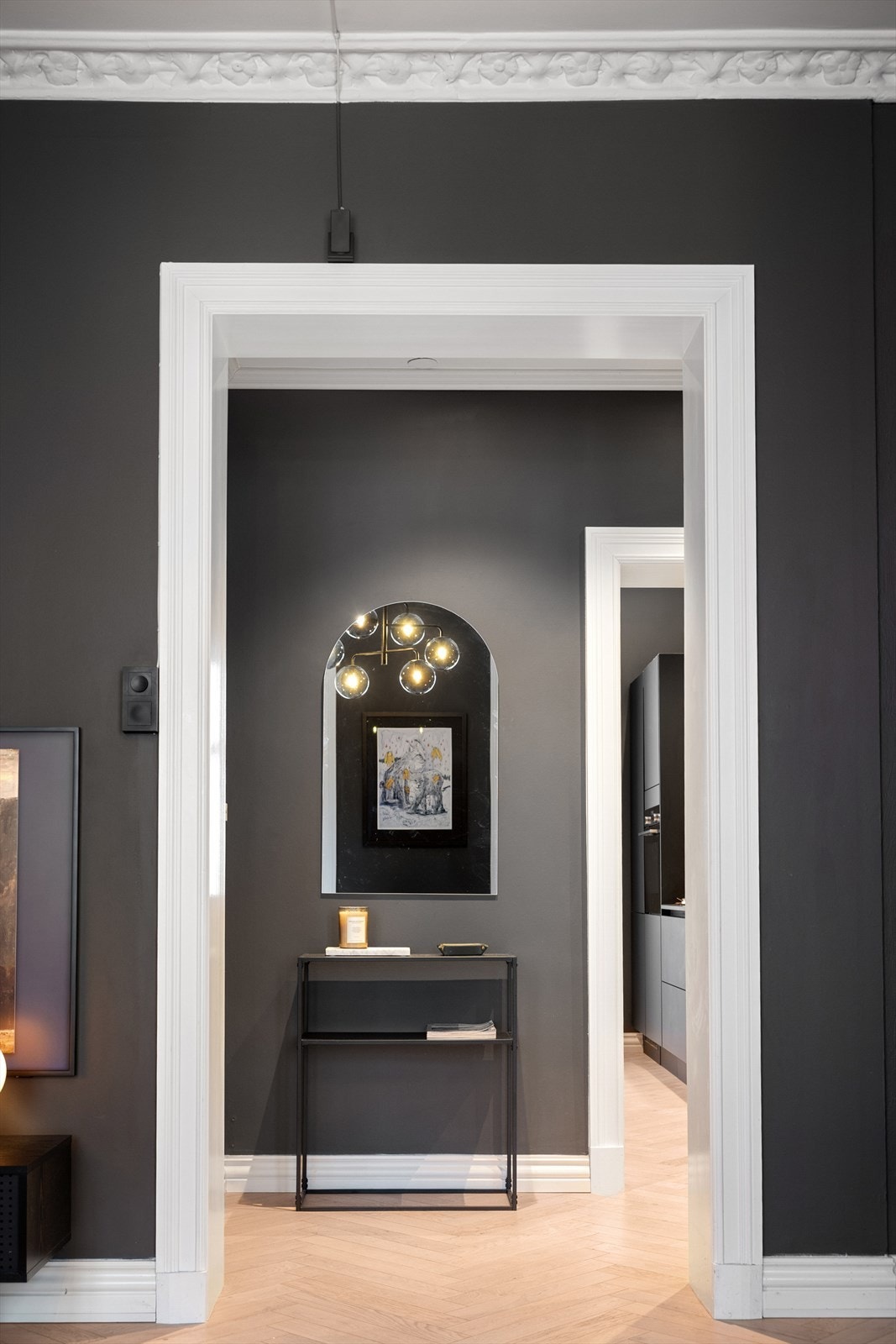 Leiligheten har stilrene og gjennomførte overflater med fiskebeinsparkett og veggene er malt i mørke fargetoner som gir en lun følelse. Galleribilde