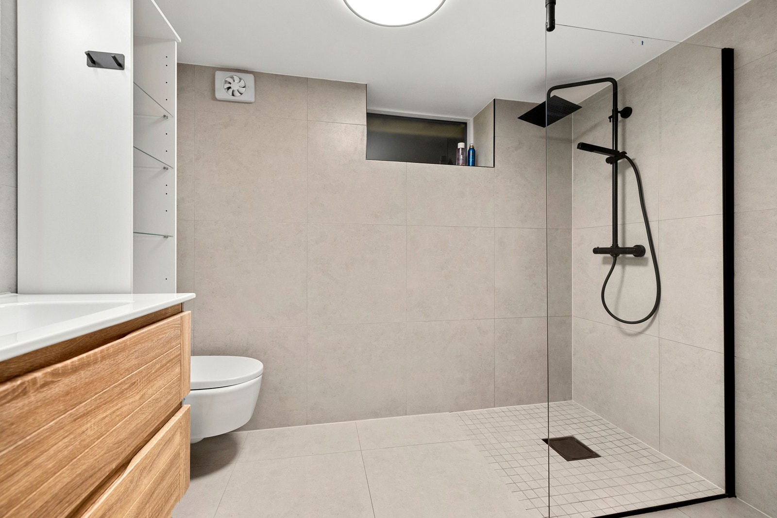 Badet ble oppgradert i 2022 og har en moderne utførelse med lyse grå fliser på både vegg og gulv. Galleribilde