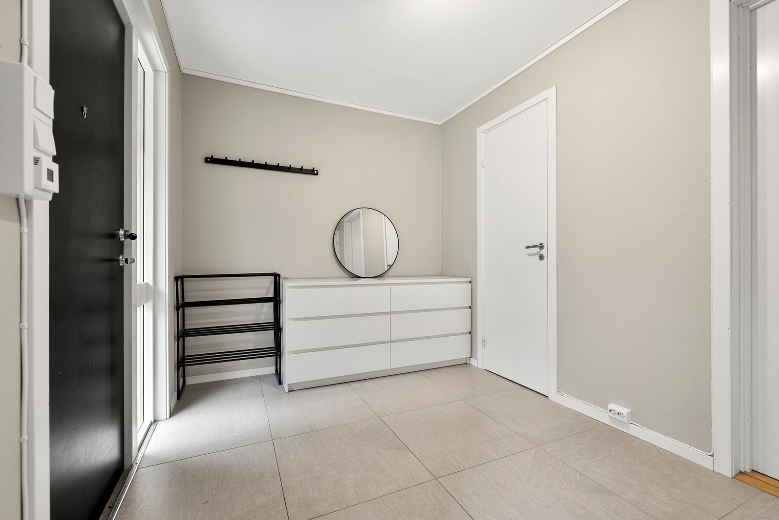 Stor og lys entré med praktiske fliser på gulv. God plass til oppbevaring. Galleribilde