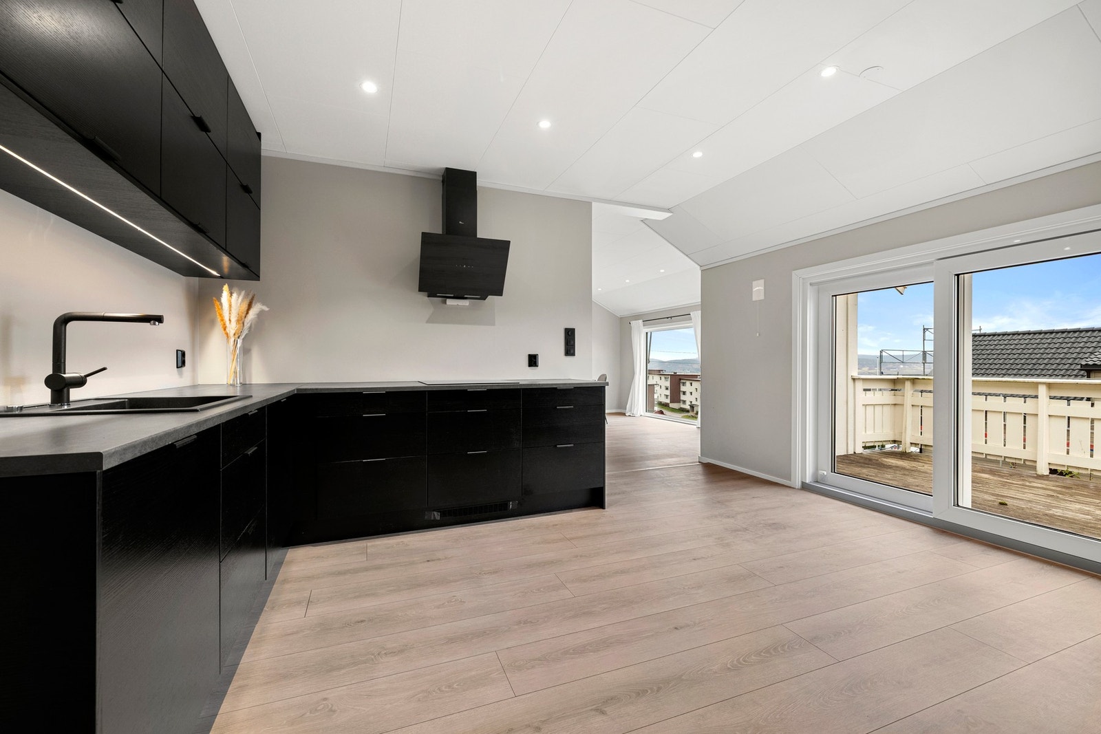 Kjøkkenet er utstyrt med finerte fronter, laminat benkeplate, integrert stekeovn, induksjonstopp, kjøl-/fryseskap, oppvaskmaskin, oppvaskkum og ventilator. Galleribilde