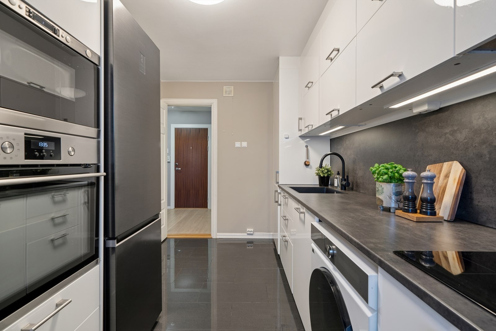 Kjøkkenet er utstyrt med ettgreps blandebatteri, nedfelt kum, mikro, komfyr, induksjonstopp, kjøkkenventilator, oppvaskmaskin og vaskemaskin. Galleribilde