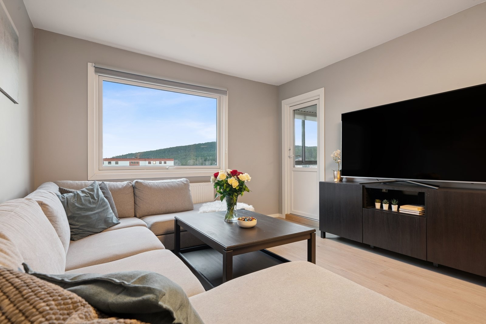 Innbydende stue med store vindusflater og behagelige fargetoner. Galleribilde