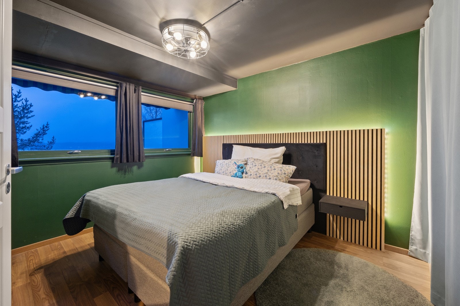 Leiligheten har et romslig og tiltalende soverom med malte veggflater, laminatgulv og to store vinduer som slipper inn rikelig med lys. Galleribilde