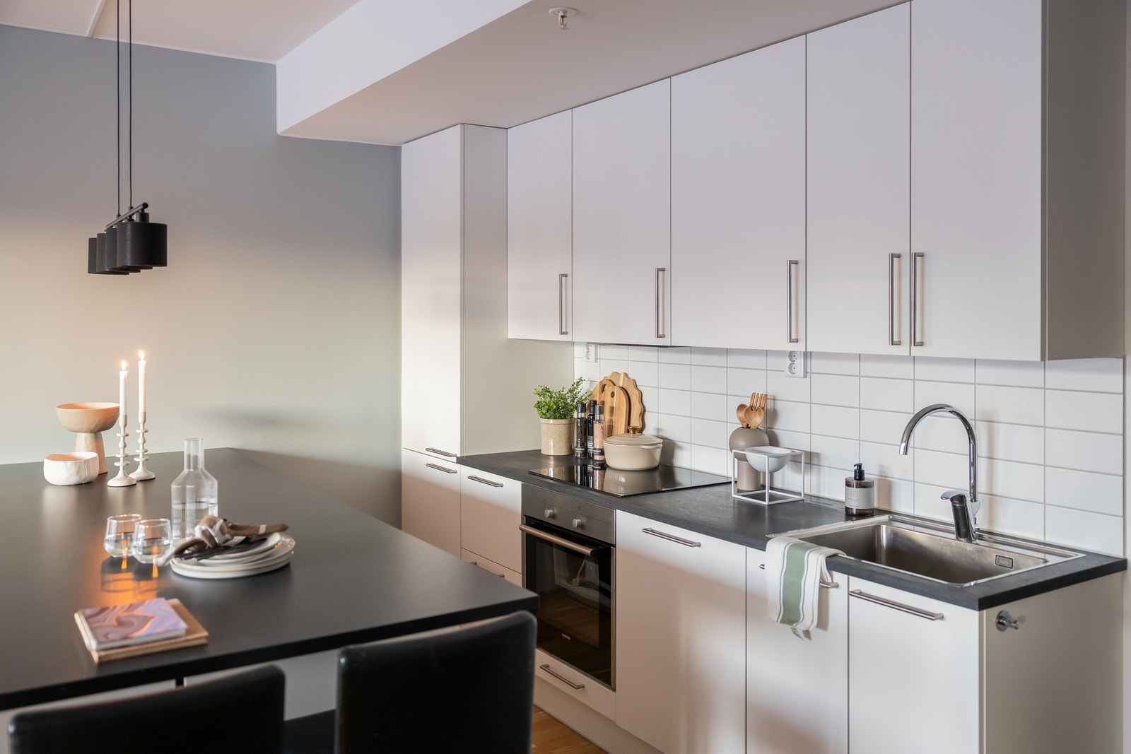 Integrerte kjøleskap med frys i nedre del, oppvaskmaskin, komfyr og induksjonstopp. Galleribilde